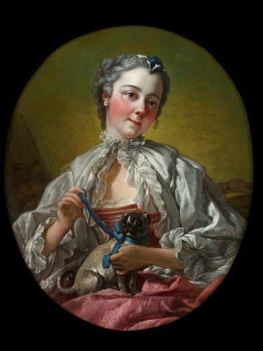 A young lady holding a pug dog